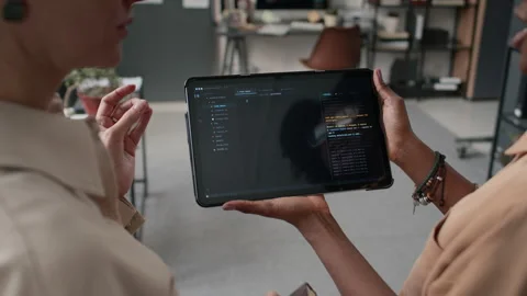 Two Unrecognizable Women Discussing Code Displayed on Screen of Tablet in Office Stock Footage 333216093