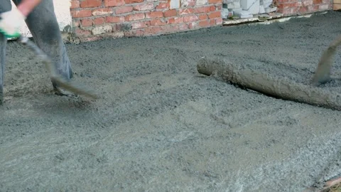 Two unrecognizable workers spreading the raw concrete near the house with shovel Stock Footage 284824472