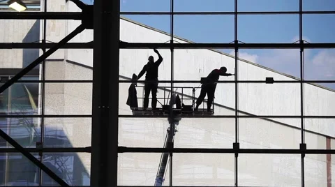 Two unrecognized washers washing windows.Industrial Climbers, facade cleaning Stock Footage 52583155
