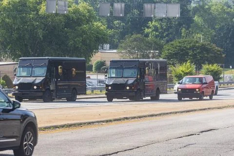 Two UPS trucks travel down an Atlanta street Stock Photos