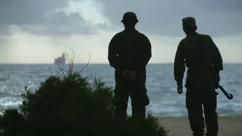 Two U.S. marines waiting on the beach Stock Footage 117734830