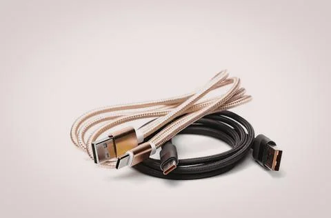 Two usb-c cables, one beige and one black, on white background Stock Photos