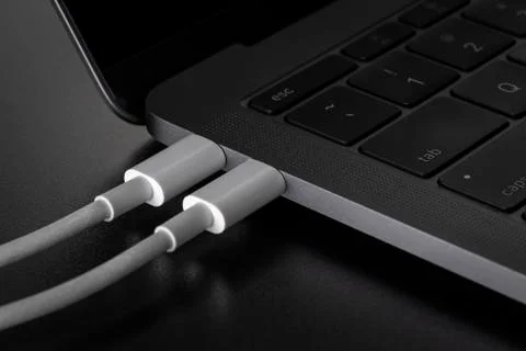 Two USB type C cables connected to laptop Stock Photos