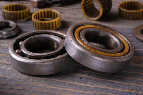 Two used bearings on a wooden table close-up. Stock Photos