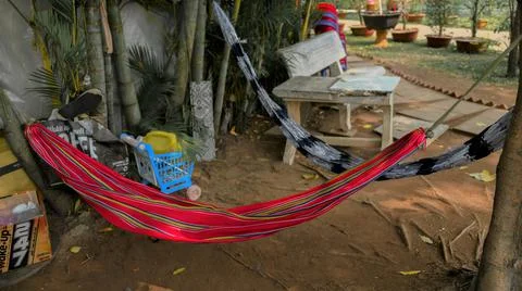 Two used hammocks hanging in the corner of the park for outdoor napping. Stock Photos