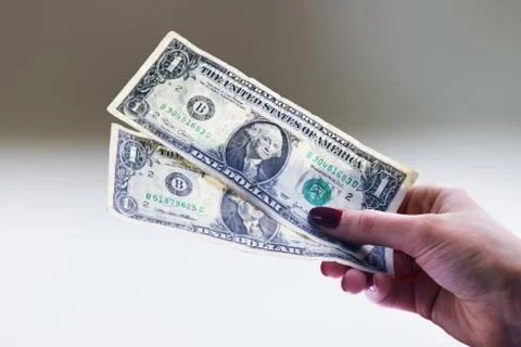 Two used one dollar banknotes in a woman's hand Stock Photos