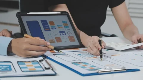 Two UX UI designers brainstorming mobile app wireframes in a modern startup.. Stock Footage 321353071