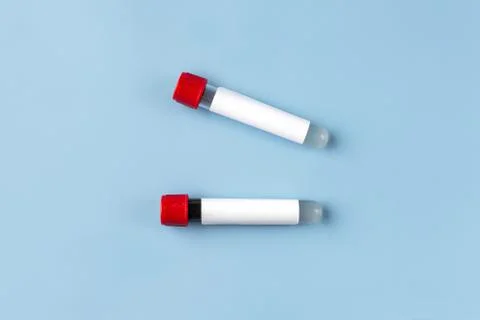Two vacuum blood test tubes with a blank label for inserting text on a blue b Stock Photos