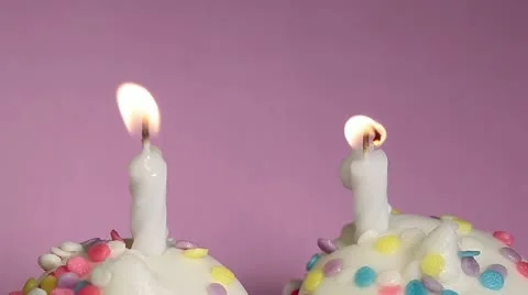 Two vanilla birthday cupcakes over pink Stock Footage 11016912