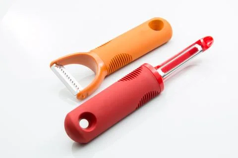 Two vegetable peelers with soft rubber handles on a white background. Stock Photos