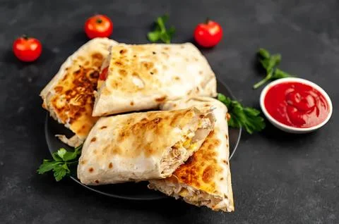 Two vegetable quesadillas with salsa on dark background Stock Photos