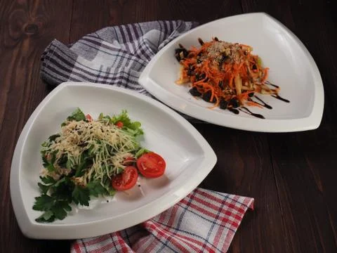 Two vegetable salads in triangular plates Stock Photos