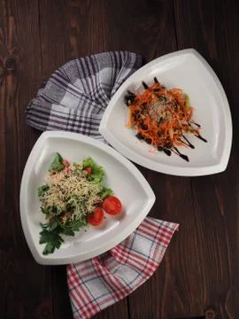 Two vegetable salads in triangular plates Stock Photos