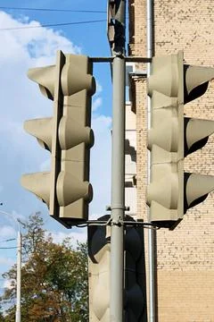 Two vertical traffic lights mounted on a metal pole against a brick building Stock Photos