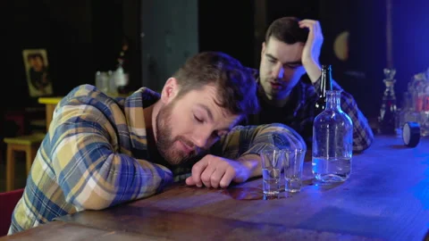 Two very drunken men in a bar pub, one of them sleeps on a table Video stock 231677123