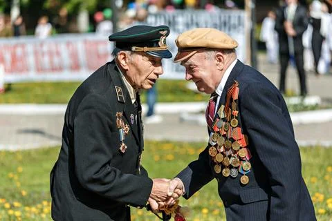 Two veterans of the Second World War congratulate each other on the Victory Day Stock Photos