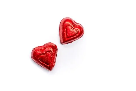 Two vibrant red heart-shaped candies rest on a clean white background Stock Photos