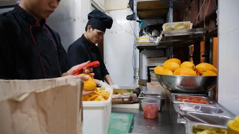 Two vietnamese chefs preparing ingredients for further cooking in restaurant Stock Footage 147349178