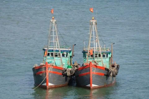 Two vietnamese fishing boats anchored together Stock Photos