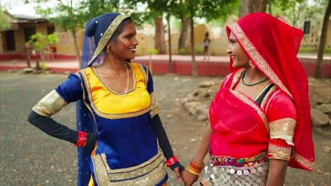Two village dancers giggle while chatting at fairground Stock Footage 308057453
