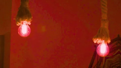 Two vintage glowing light bulbs hanging with rope against orange wall decor Stock-Footage 341801395