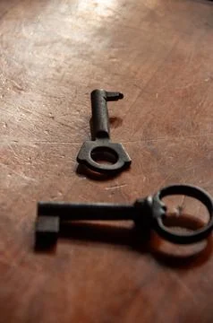 Two vintage skeleton keys on a rustic wooden background Stock Photos