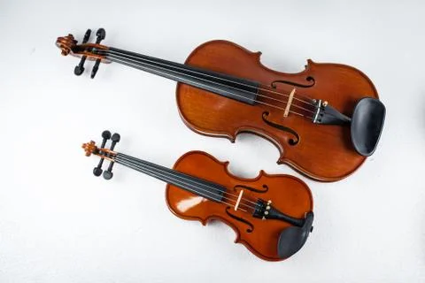 Two violins put on white background,show the different size of violin. Stock Photos