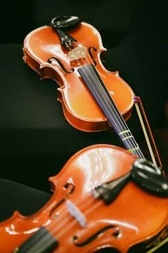 Two violins on some chairs Stock Photos