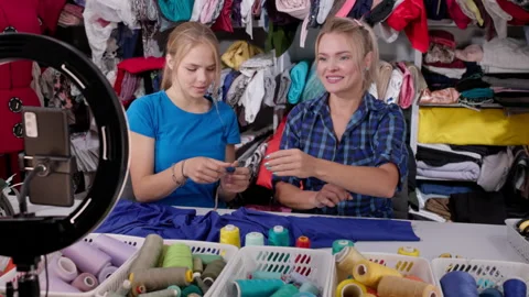Two vloggers have found the right color of thread and are showing it to the Video stock 244983990