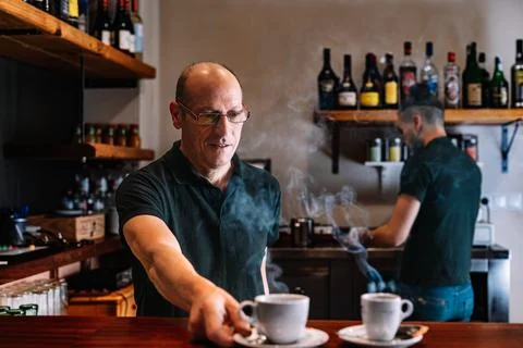 Two waiters at work, preparing coffee for their customers. Two co-workers in Stock Photos