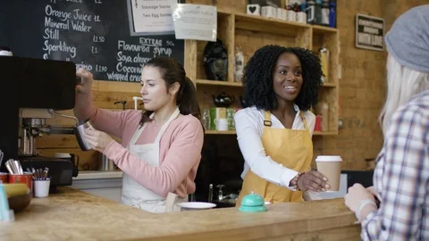 Two waitress taking orders, serving coffee and smiling at camera at counter Stock Footage 108037967