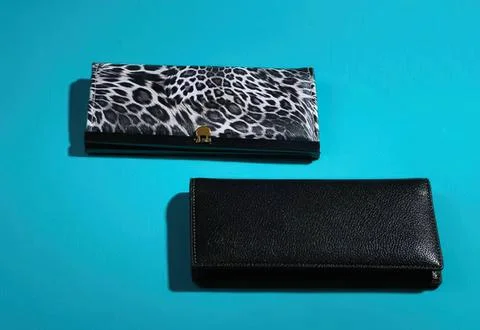 Two wallets on a blue background, one with animal print design Stock Photos