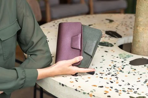Two wallets in the lady hand on the table Stock Photos
