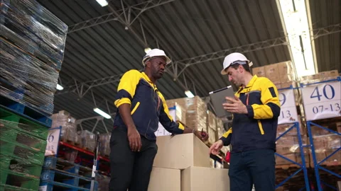Two warehouse workers are reviewing the list of items based Stock Footage 308938785