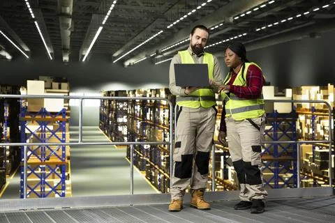 Two warehouse workers collaborating as a team in distribution center 库存照片