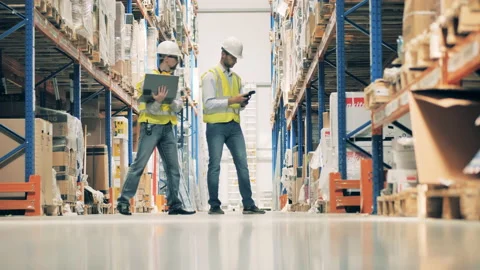 Two warehouse workers discussing goods in stock Stock Footage 142589816