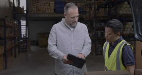 Two Warehouse Workers Looking at Digital Tablet Technology Stock Footage 254609044
