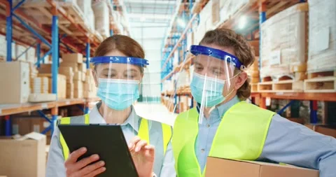Two warehouse workers stand in the background of the rows of parcels and look in Video stock 151778608