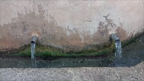 Two water pipes pouring fresh spring water outdoors 動画素材 338336567
