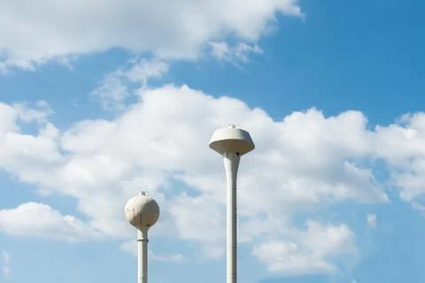 Two water tower top under blue cloudy sky Stock Photos