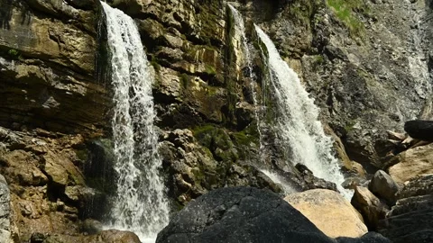 Two waterfalls cascade in front of rocks in summer Stock Footage 260813536