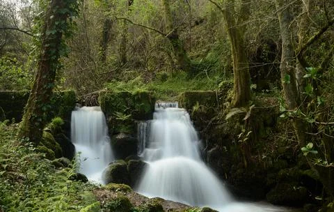 Two waterfalls flowing through two holes Stock Photos
