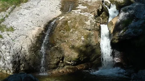 Two waterfalls run over rocks in the summer (slow motion) Video stock 219398379