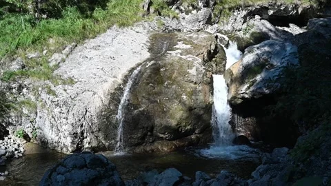Two waterfalls run over rocks in the summer (slow motion) Video stock 219398797