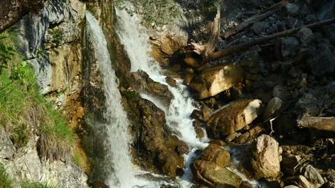 Two waterfalls splash on rocks from a mountain stream Video stock 260815690