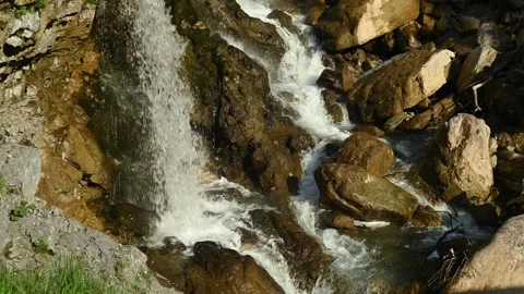 Two waterfalls splash on rocks from a mountain stream Video stock 260931931