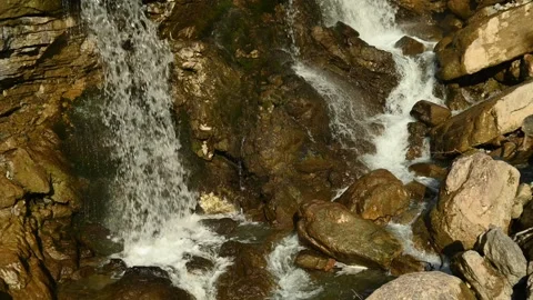 Two waterfalls splash on rocks from a mountain stream Video stock 260932065