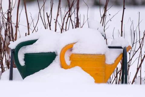 Two watering cans in deep snow Stock Photos
