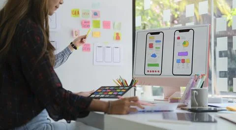 Two web designers are working and designing user interface for website and ap Foto stock