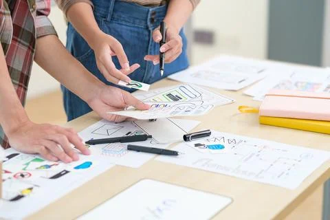 Two web designers are working and designing user interface for website and .. Foto stock